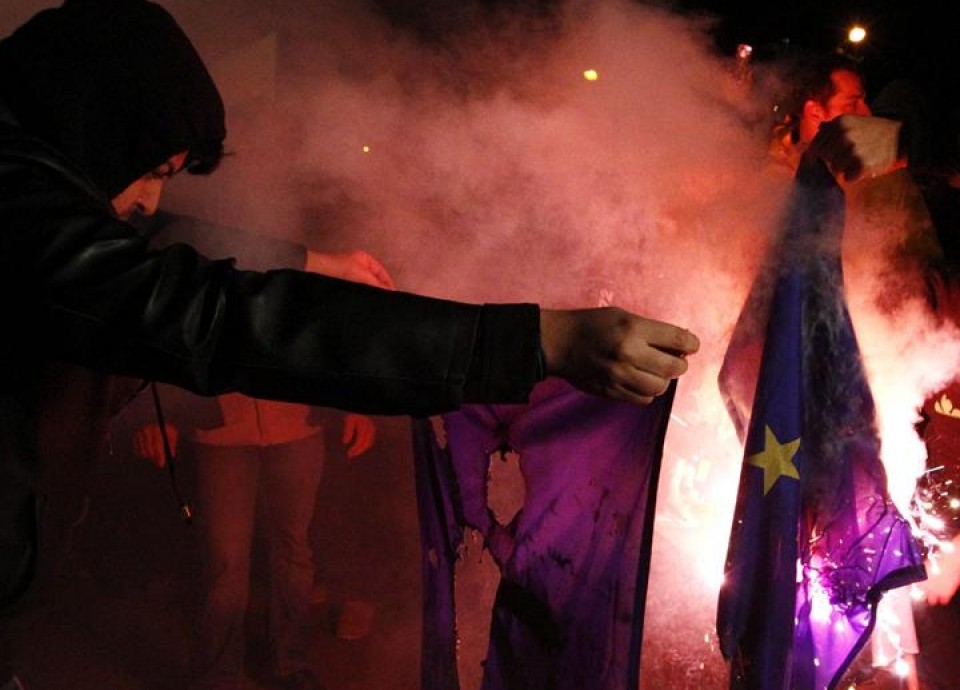 Varios asistentes queman una bandera de la UE frente al Parlamento de Chipre. EFE