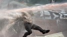 Manifestante arrollado por un chorro de agua a presión. Foto: EFE. title=