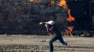 Un manifestante lanzando un coctel molotov. Foto: EFE. title=
