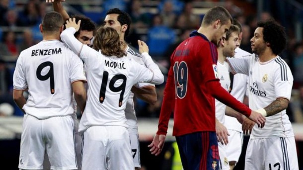 Jugadores del Real Madrid festejan el primer gol, ante un Riera cabizbajo. Efe.