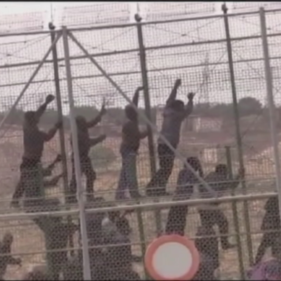 Inmigrantes intentando saltar la valla de Melilla.