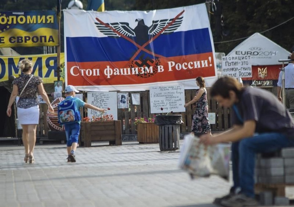 Oinezkoak "Errusiaren faxismoari ez" dioen pankarta baten aurrean, Kieven. EFE