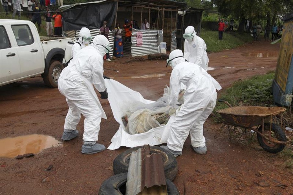Erizainak Liberian, ebolak hildako pertsona lagun baten gorpua mugitzen. Efe