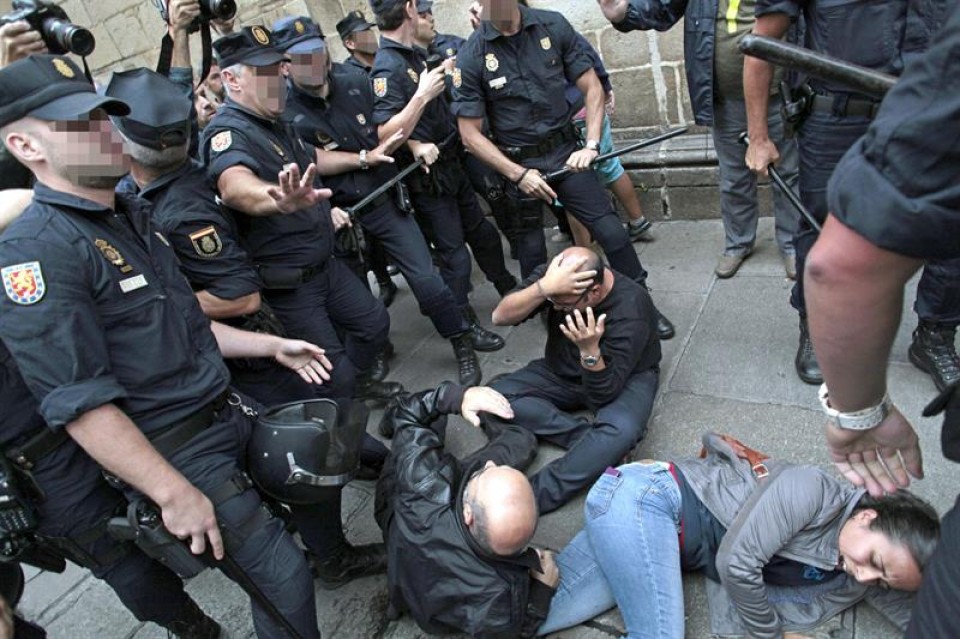 Manifestantes golpeados por la Policía. EFE