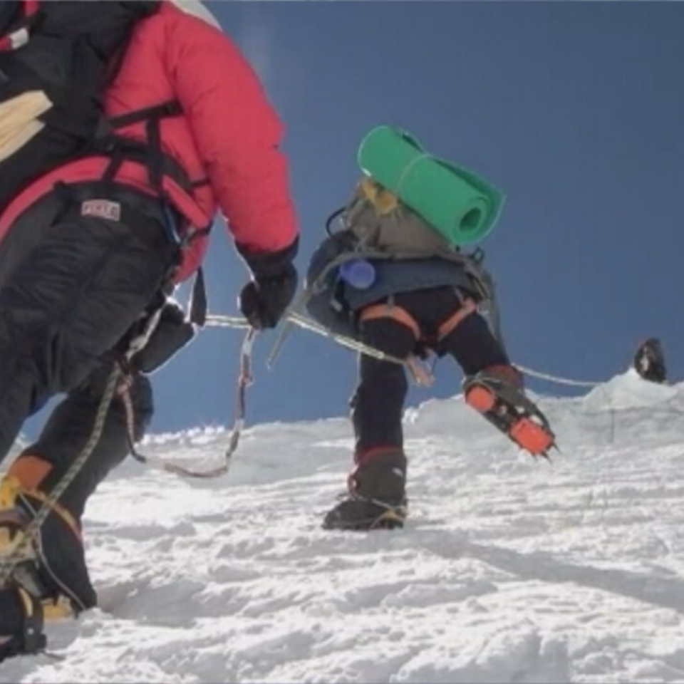 Montañeros ascendiendo por una ladera helada