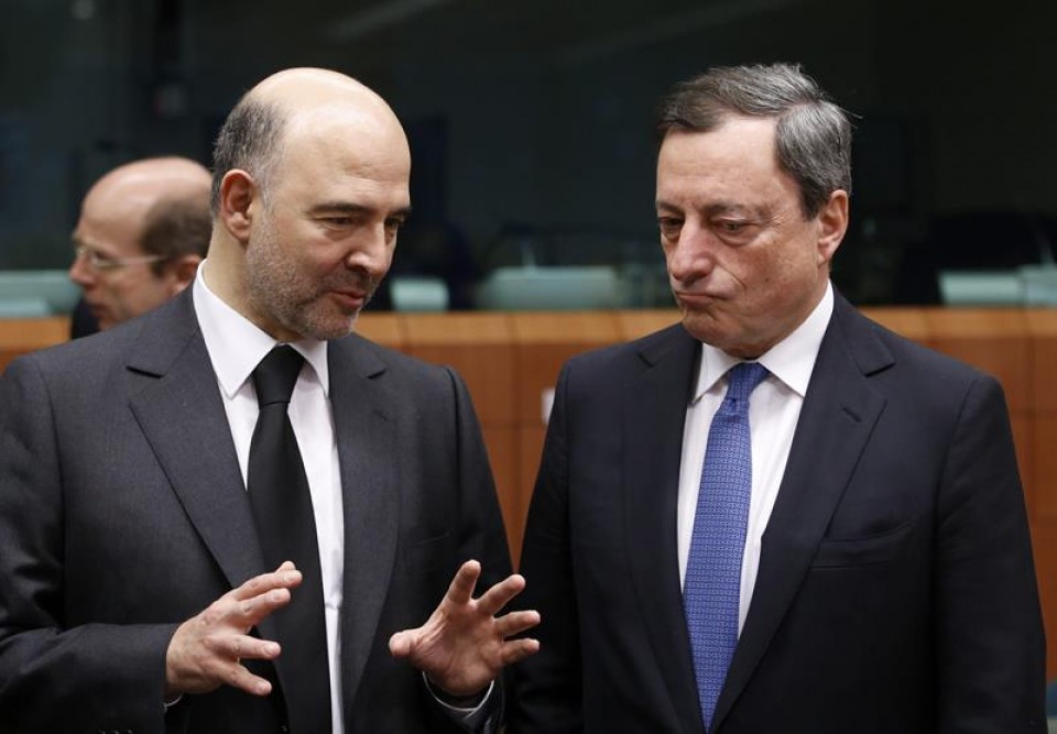 El comisario de Asuntos Económicos, Pierre Moscovici, habla con el presidente del BCE, Mario Draghi.