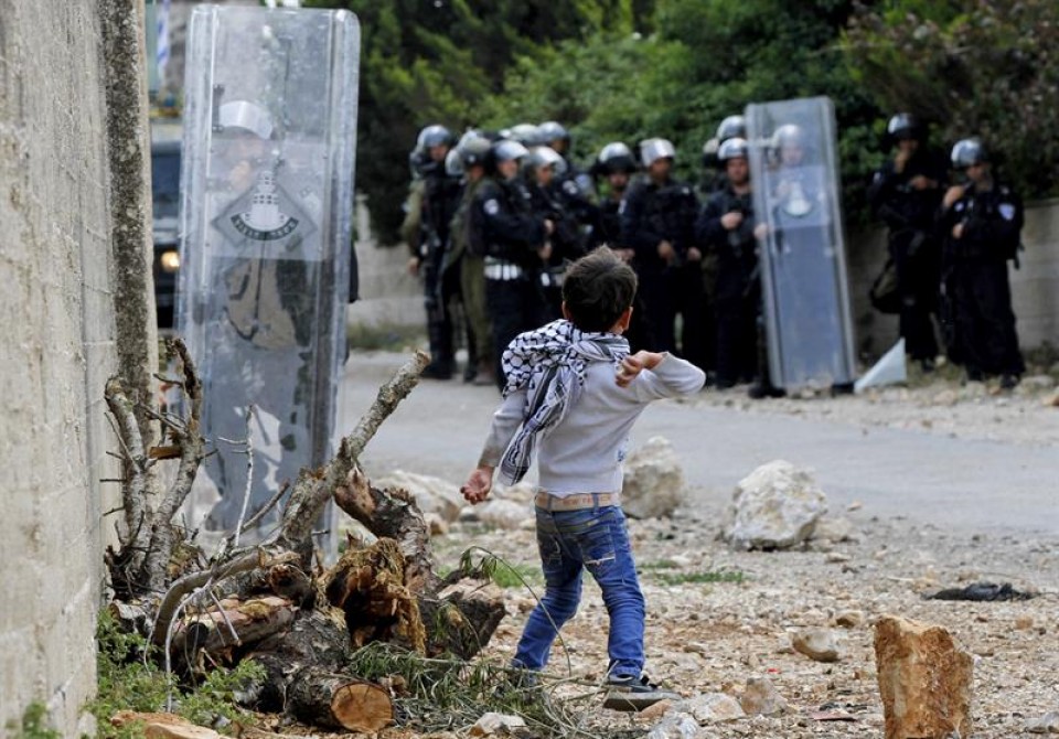 Un niño palestino lanza una piedra a soldados israelíes en Qadomem. EFE