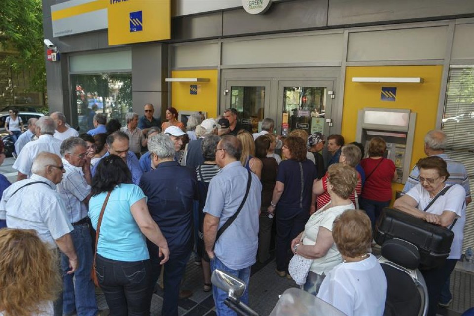 Pensionistas hacen cola para retirar dinero a la entrada de una sucursal bancaria en Salónica. EFE