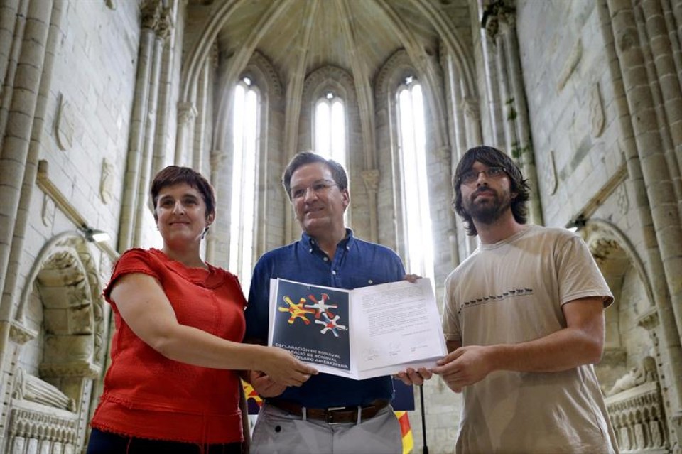 Maite Ubiria (EH Bildu), Xavier Vence (BNG) y Roger Castellanos (CUP) posan con el documento. EFE