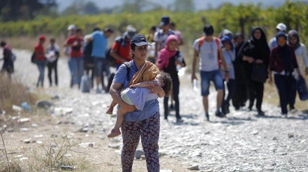 Refugiados cruzan la frontera entre Macedonia y Grecia. Foto: EFE