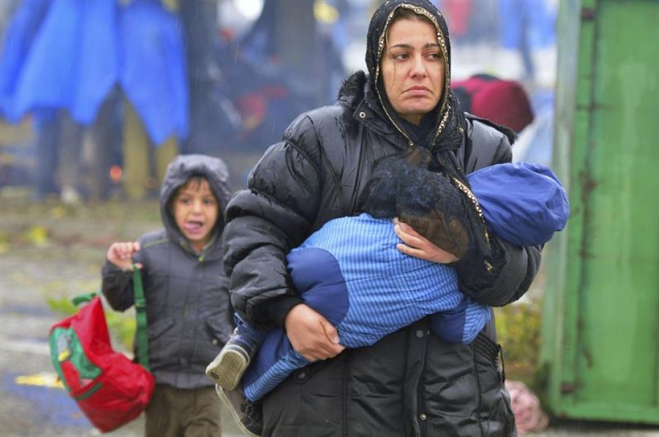 Una mujer camina con su hijo en brazos en la frontera entre Croacia y Eslovenia. EFE