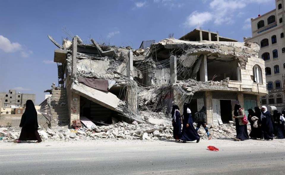 Un grupo de yemeníes camina junto a un edificio dañado por los bombardeos en Saná. Foto: EFE