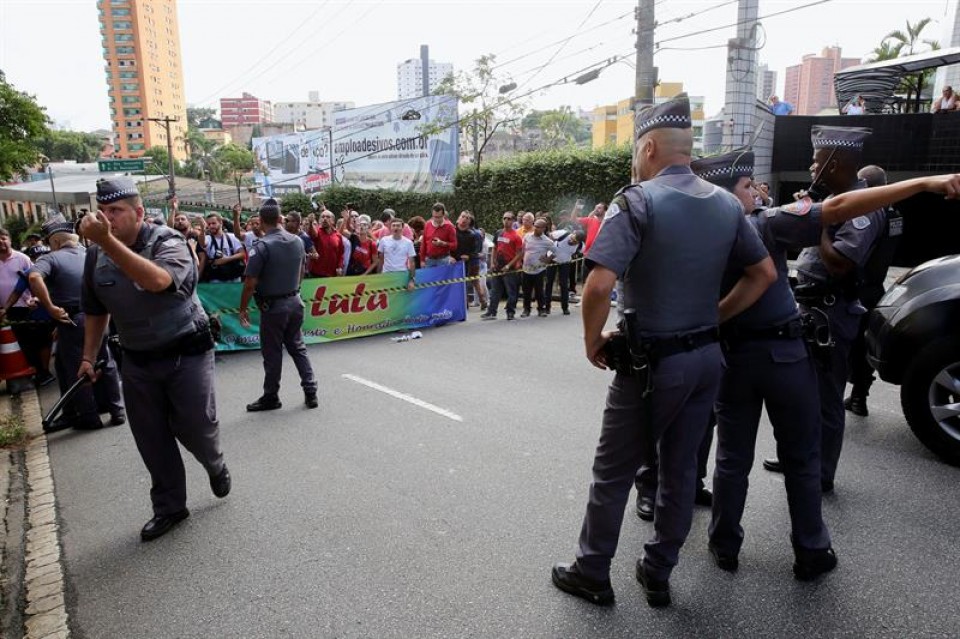 Agentes de Policía y curiosos ante la residencia de Lula, en la periferia de Sao Paulo. Foto: EFE