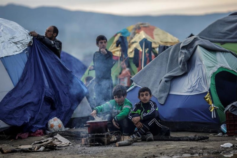 Un grupo de refugiados arman carpas mientras esperan en Idomeni (Grecia). Foto: EFE