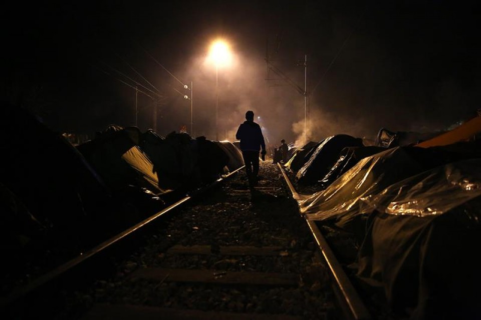 Un refugiado camina en las vías del tren en el campamento de Idomeni (Grecia). Foto: EFE