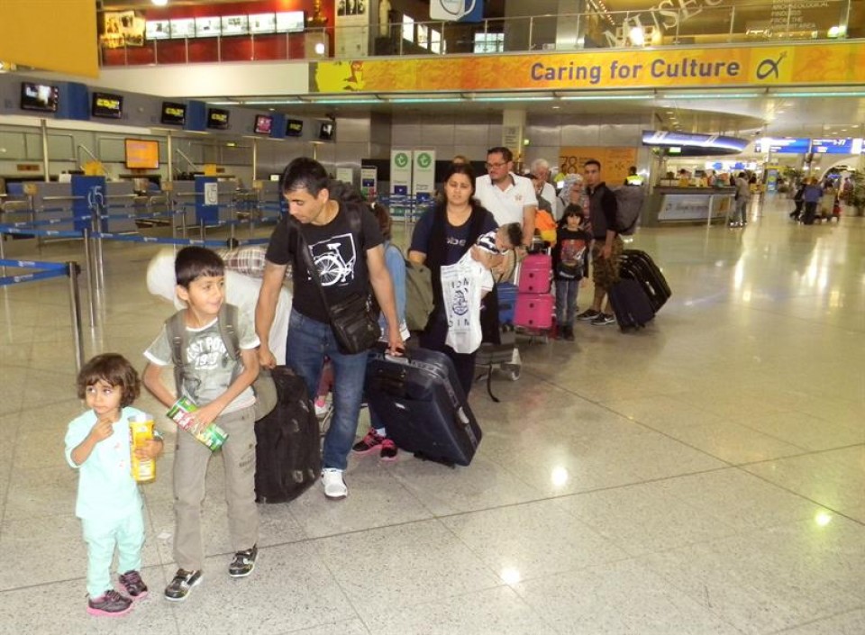 Los refugiados en la cola de facturación en el aeropuerto de Atenas antes de partir hacia Madrid.EFE