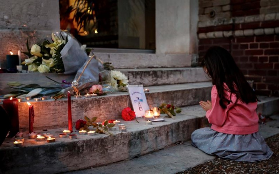 Una niña ora junto a un memorial por las víctimas en Saint-Etienne-du-Rouvray (Francia). Foto: EFE