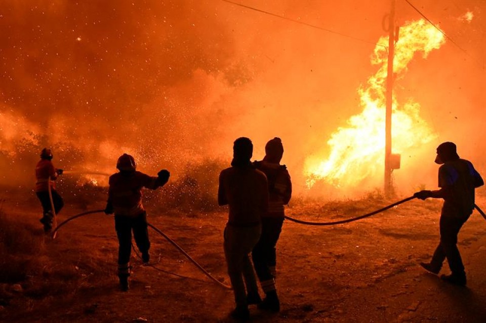 Vecinos ayudan a los bomberos a extinguir las llamas del incendio forestal. Foto: EFE