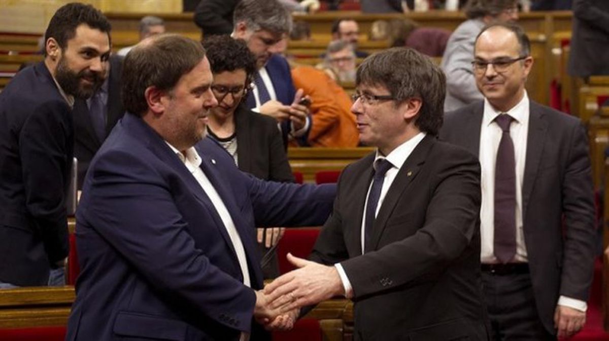 Junqueras y Puigdemont se saludan en el Parlament tras aprobar los presupuestos. Foto: EFE