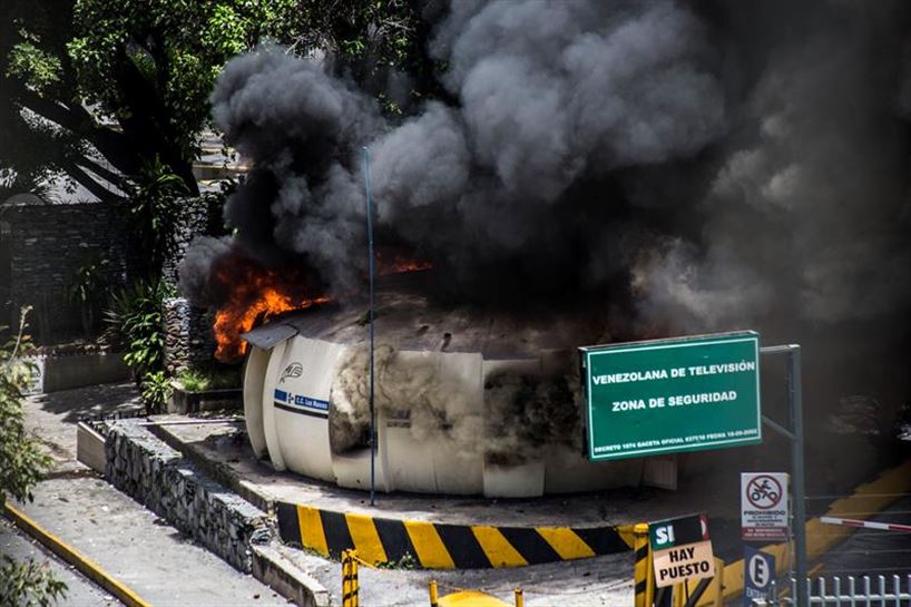 Modulo de la Policía en llamas en Caracas. Foto: EFE