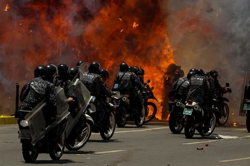 Explosión contra un grupo de policías en Caracas, ayer. Foto: EFE