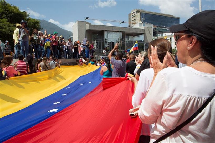 Venezolanos despliegan una bandera de Venezuela. EFE.