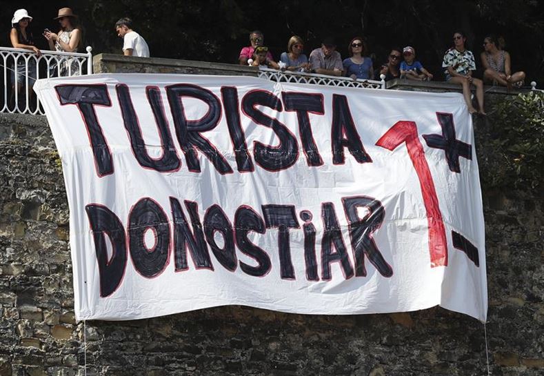 Una pancarta en Donostia para denunciar el actual modelo turístico. Foto de archivo: EFE