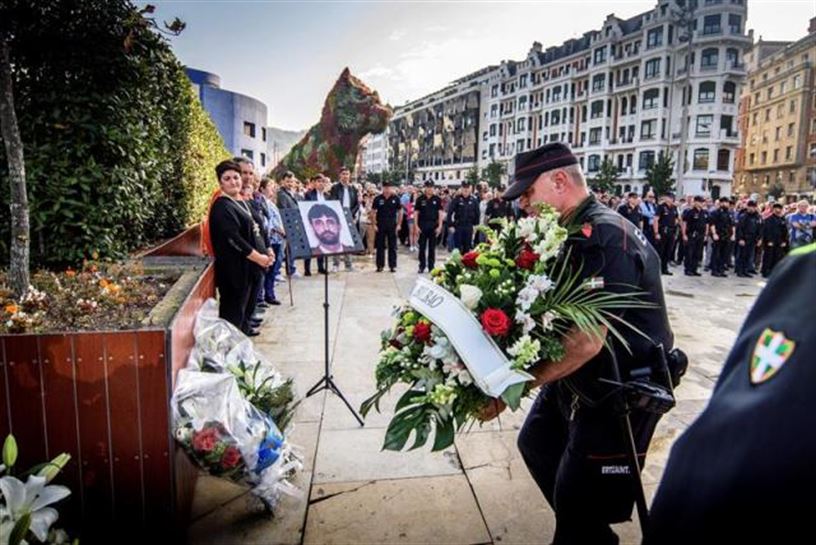 Agentes de la Ertzaintza ponen flores delante del monolito en recuerdo de Txema Agirre. Foto: EFE