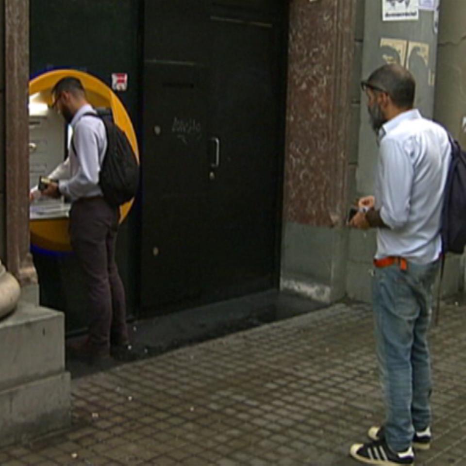 Un hombre espera ante un cajero para retirar dinero. EiTB