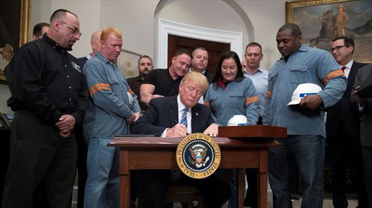 Trump, junto a trabajadores del sector, firma la medida. Foto: EFE