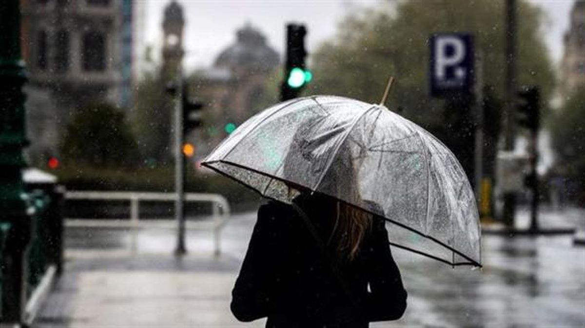 Una mujer camina bajo su paraguas en San Sebastián. Foto: EFE