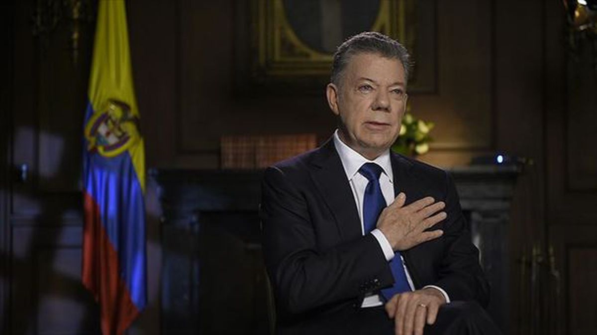 Santos, Kolonbiako presidentea, eskuineko eskua bihotzean duela, kameren aurrean
