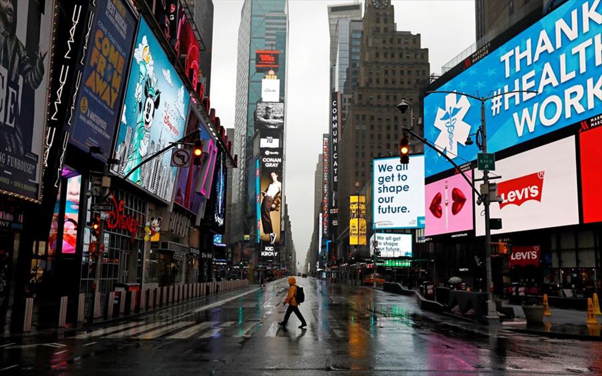 Gizon bat Manhattaneko Times Square kale-gurutzean, hutsik, koronabirusa dela eta.
