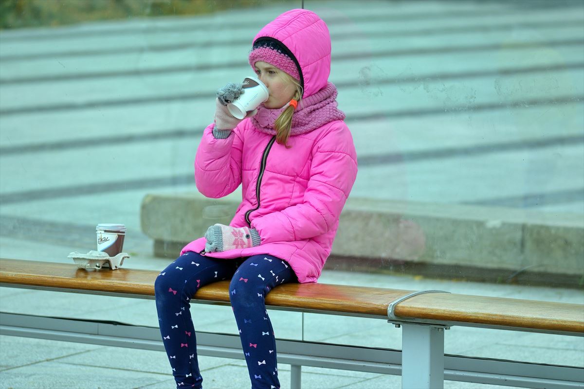 Una niña bebiendo de un vaso de plástico