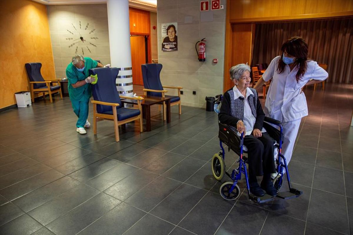 Una mujer mayor y dos trabajadores en una residencia de Vitoria-Gasteiz.