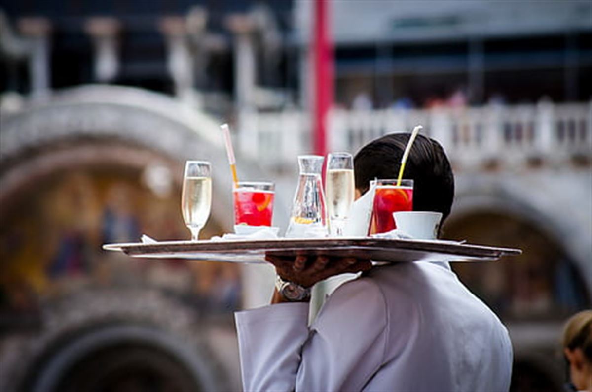 Un camarero llevando bebidas