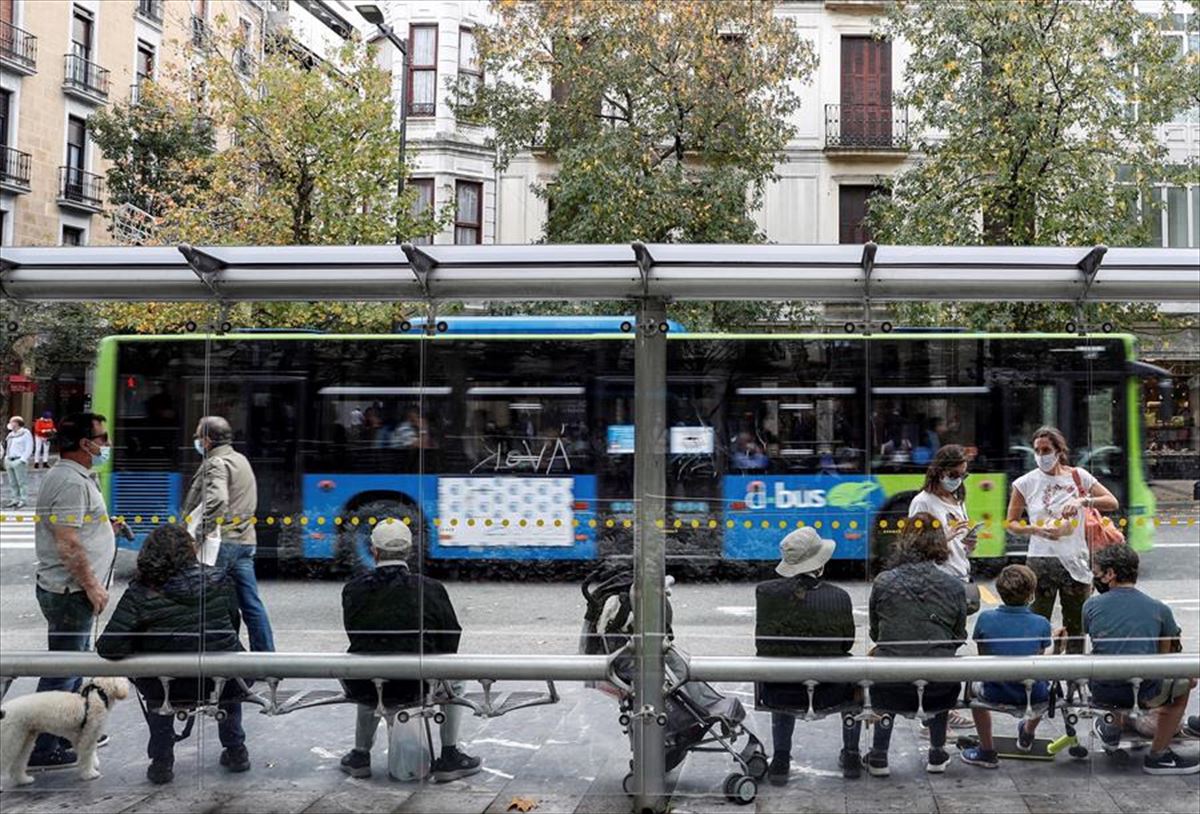 Un grupo de personas espera en una parada de autobús de San Sebastián. Foto: EFE