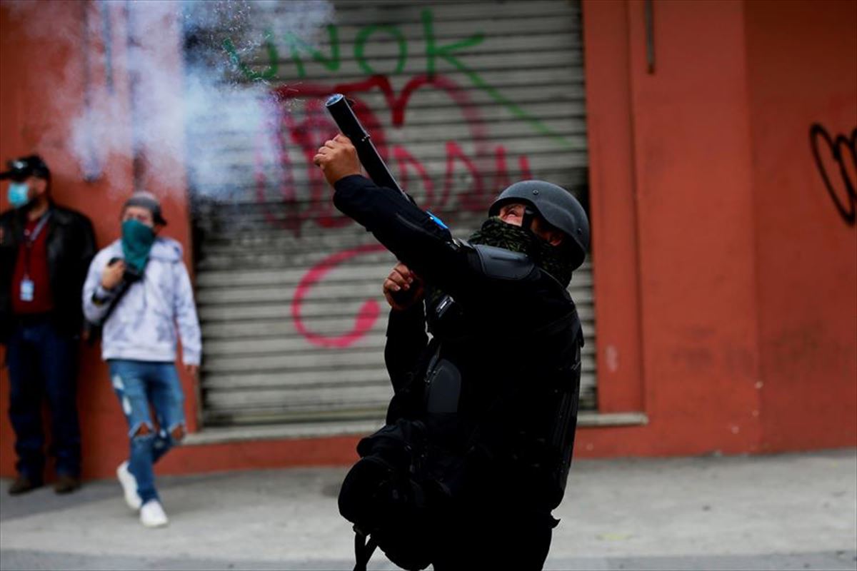 Un policía dispara durante las protestas en Guatemala. Foto: EFE