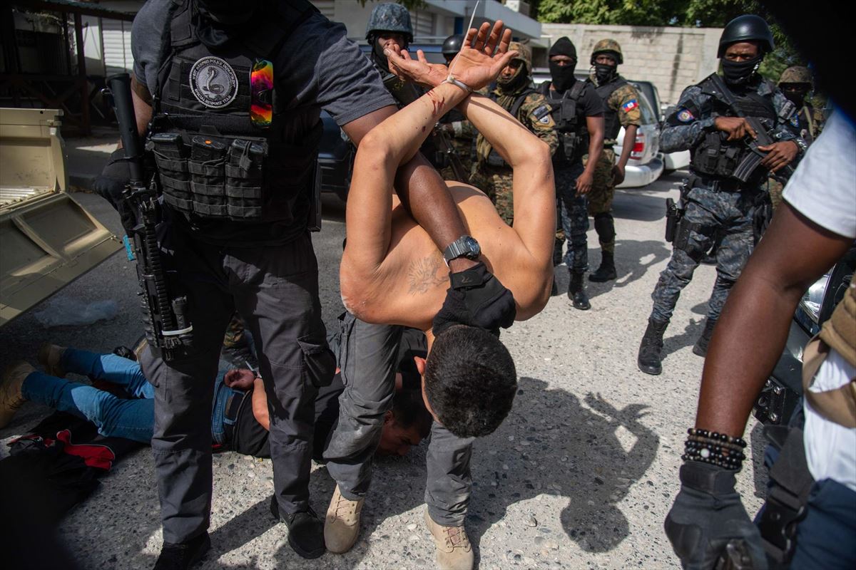 Policías custodian a un grupo de sospechosos por el asesinato del presidente haitiano.