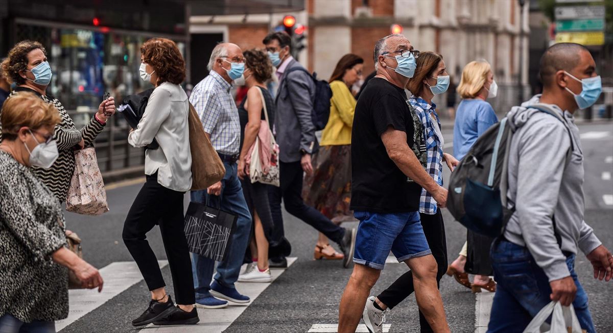 Gente con mascarilla cruzando una calle. Foto de archivo: EFE