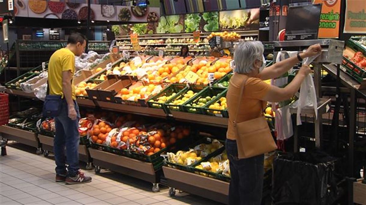 Gente en la sección de frutas y verduras de un supermercado