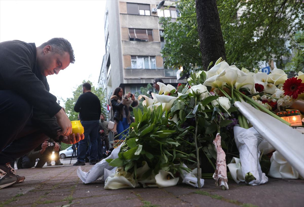 Un hombre deja un ramo de flores en el lugar del tiroteo