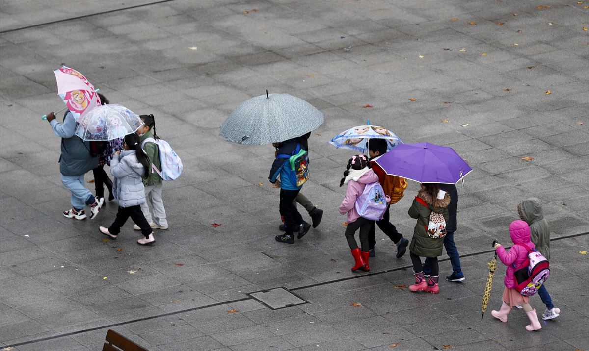 Niñas y niños con paraguas. Foto: EFE