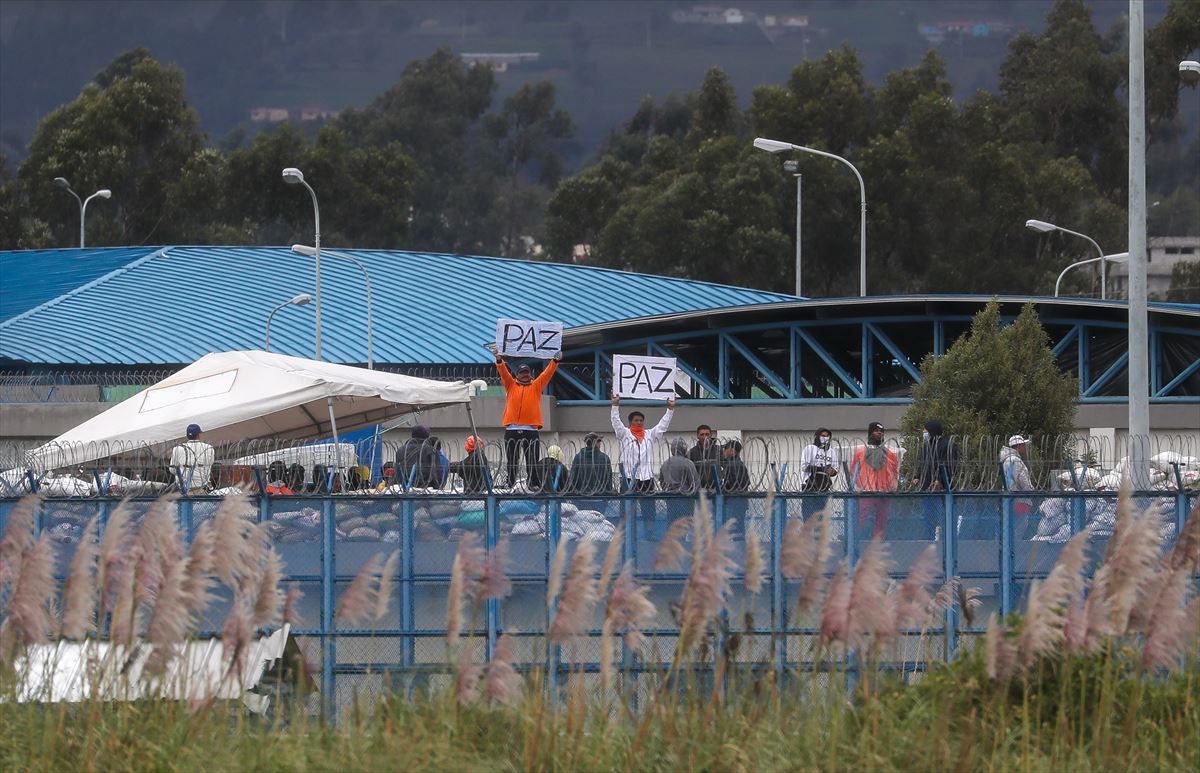 Reclusos muestran carteles en una prisión de Latacunga.