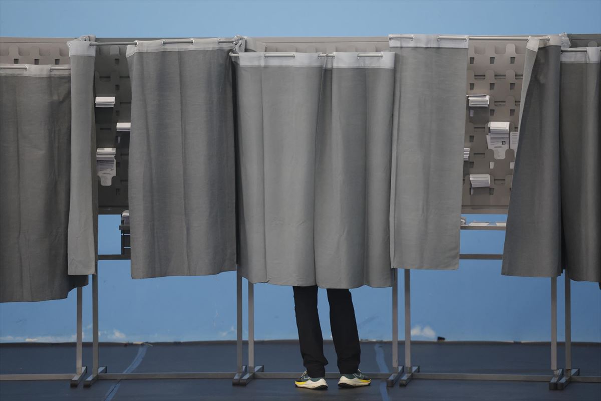 Votante tras las cortinas en un colegio electoral, ayer en Ourense. Foto: EFE