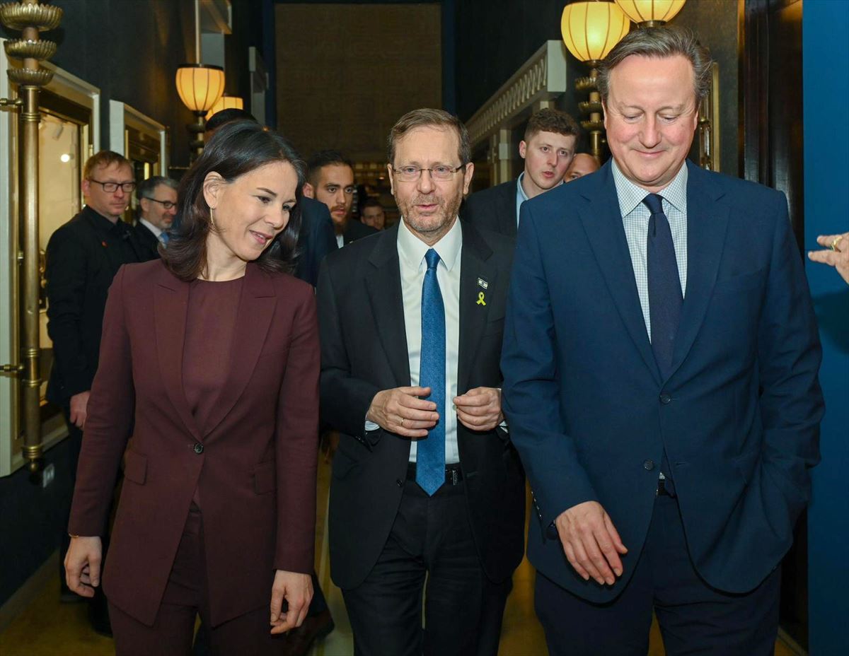 Annalena Baerbock (ezkerrean), Isaac Herzog (erdian) eta David Cameron (eskuinean).