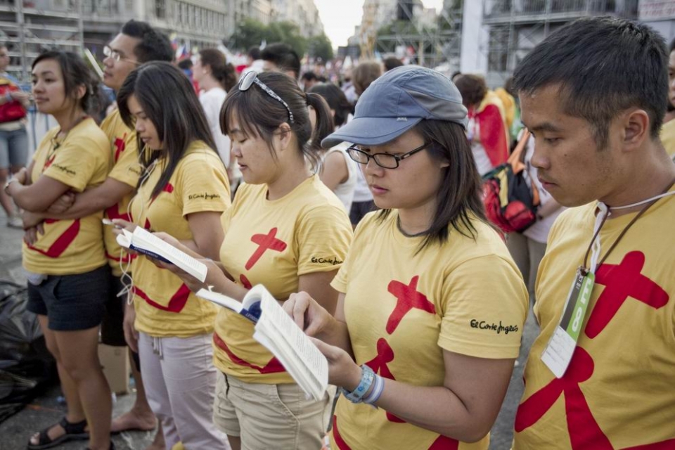 Unos jóvenes asiáticos esperan la llegada del Papa. Foto: EFE