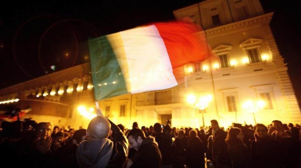 Hundreds of demonstrators waving banners celebrate Berlusconi's resignation. Photo: EFE