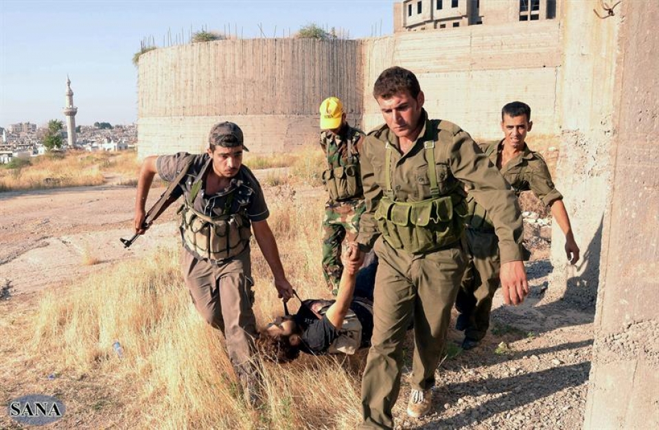 Siriako Armadako soldaduak hilotz bat eramaten. EFE