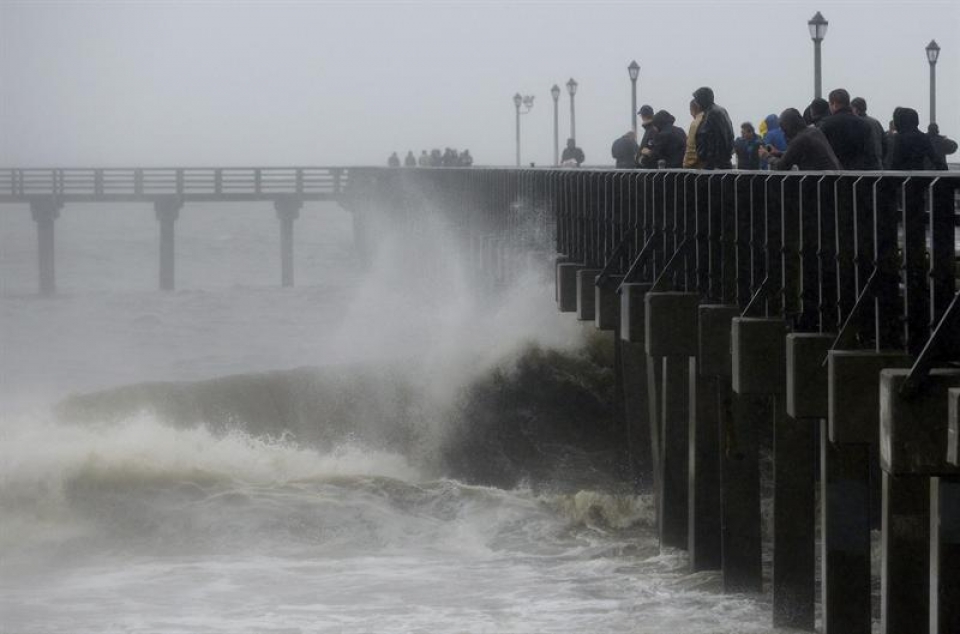 Varias personas contemplan atónitos la fuerza del mar. (EFE)